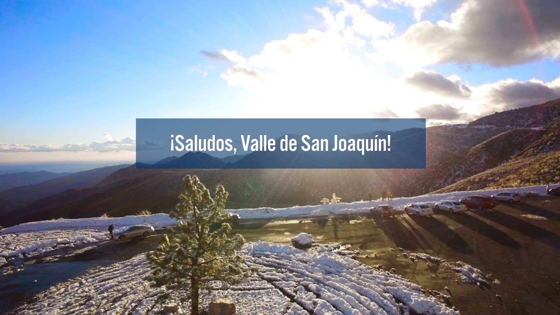 Video still depicting a scene from the San Joaquin Valley with a white-text title on a transparent blue box saying "Saludos, Valle de San Joaquin"