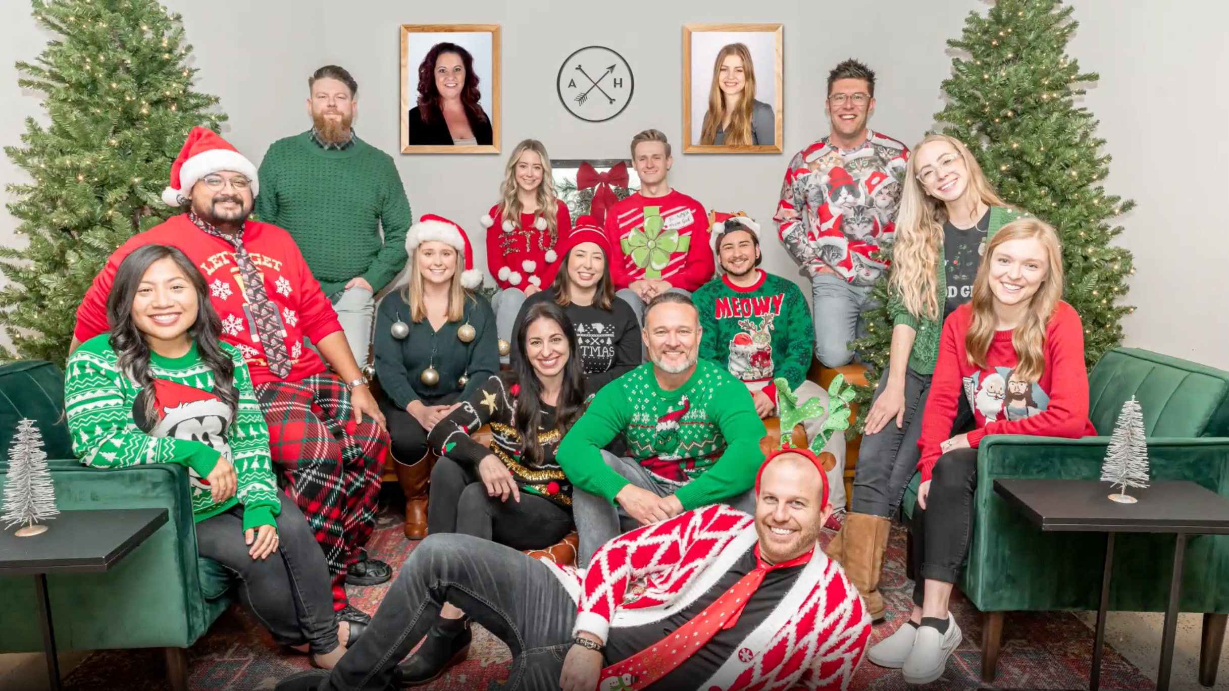 A 2021 Christmas card photo with the staff of Archer & Hound dressed up in green, red, and Christmas attire, with two christmas trees and two photos of staff members who couldn't attend the photo shoot
